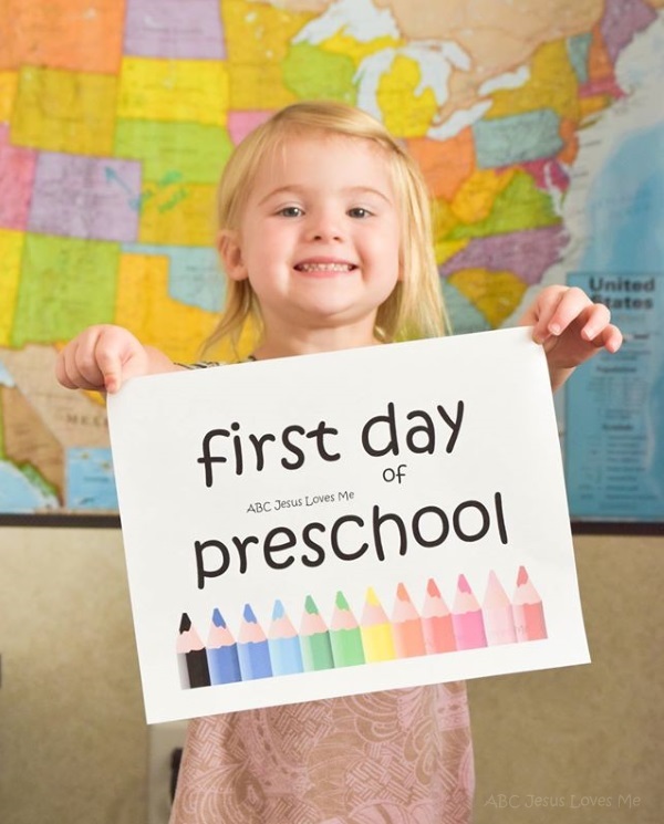 Little girl holding First Day of Preschool sign.