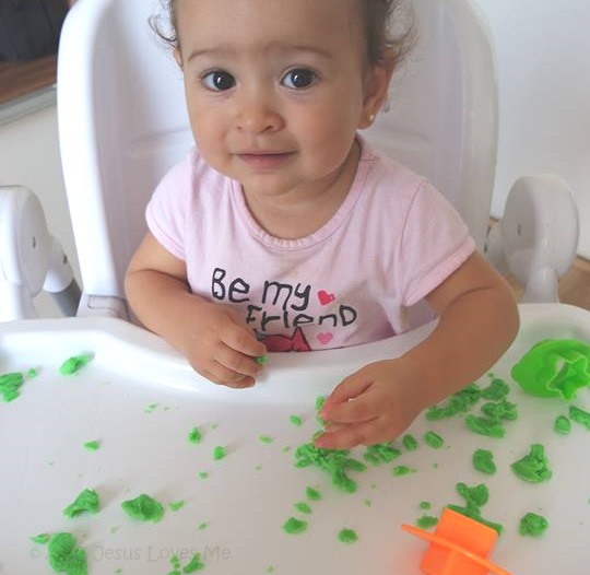 Toddler playing with play dough.