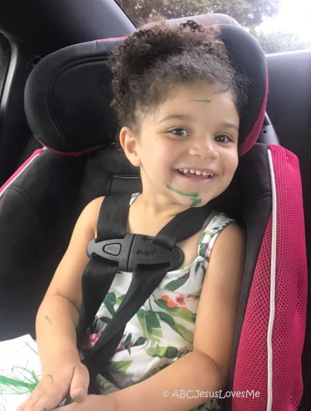 Little girl smiling in car seat