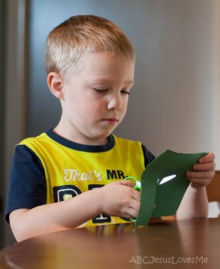 Preschool boy cutting paper.