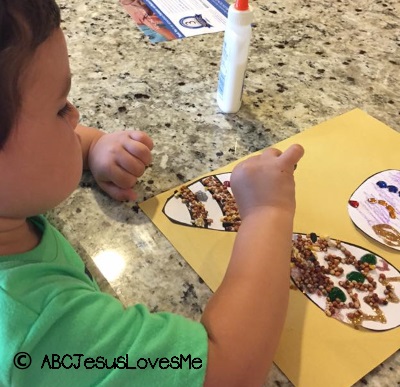 Little boy making eggs out of sensory craft supplies.