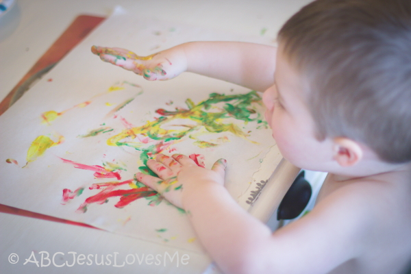 Preschool boy fingerpainting.