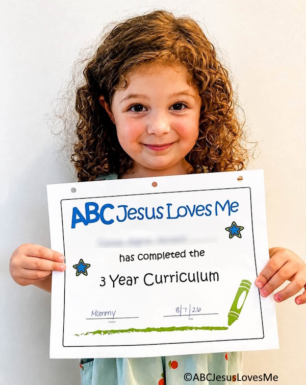 A child holding her graduation poster from ABCJesusLovesMe