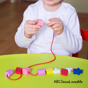 A child lacing beads.