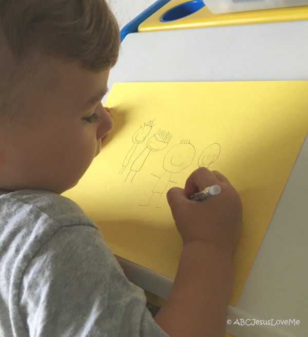 Little boy drawing his family.