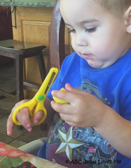 Child cutting playdough.