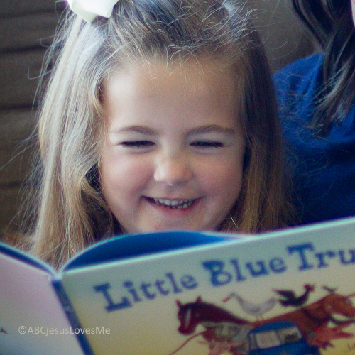 Little girl reading with her mom.