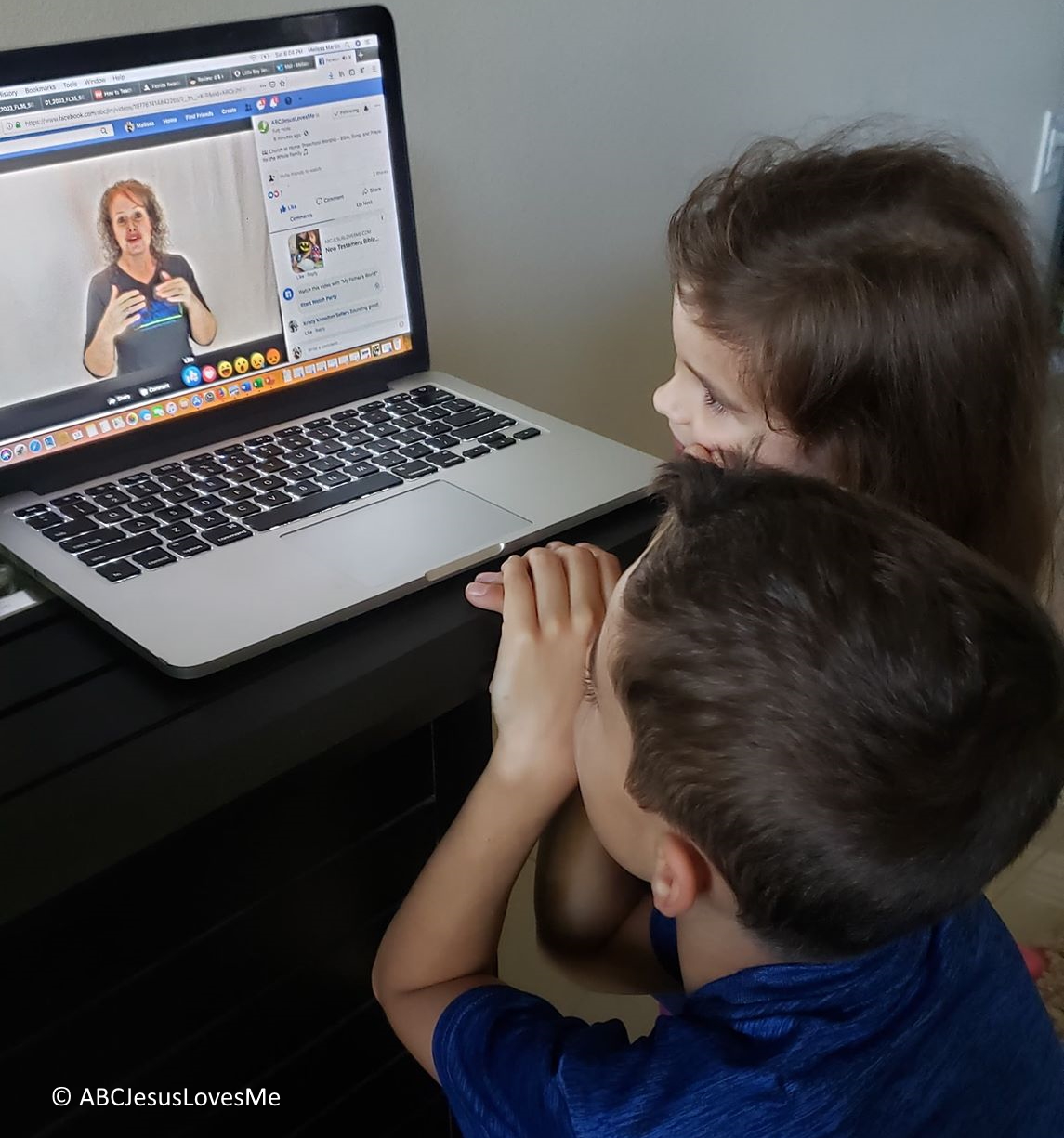 Two children watching ABCJesusLovesMe on their computer.