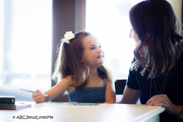 Adult teaching preschool child how to write.