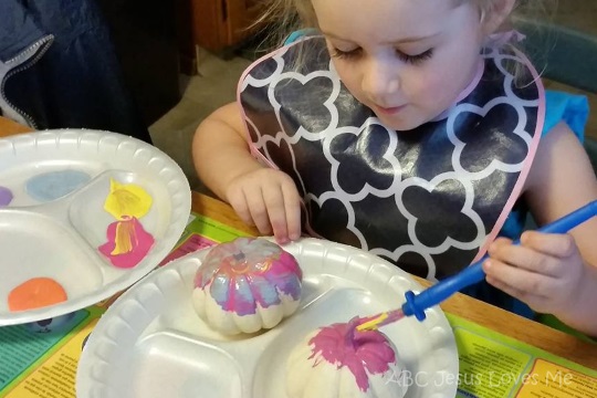 Child painting pumpkins